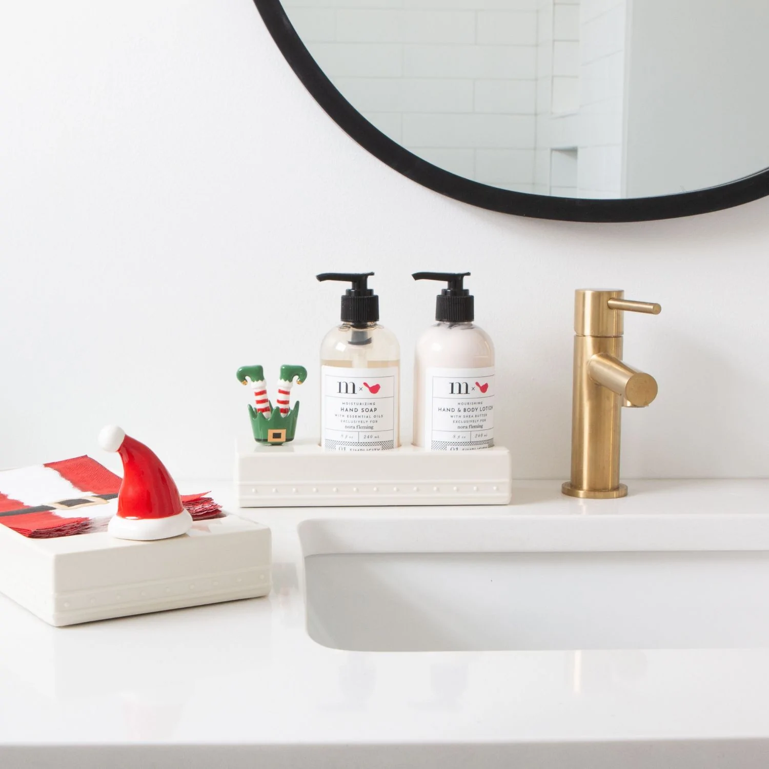 Nora Fleming Mini Santa hat attached to a soap tray in a bathrroom