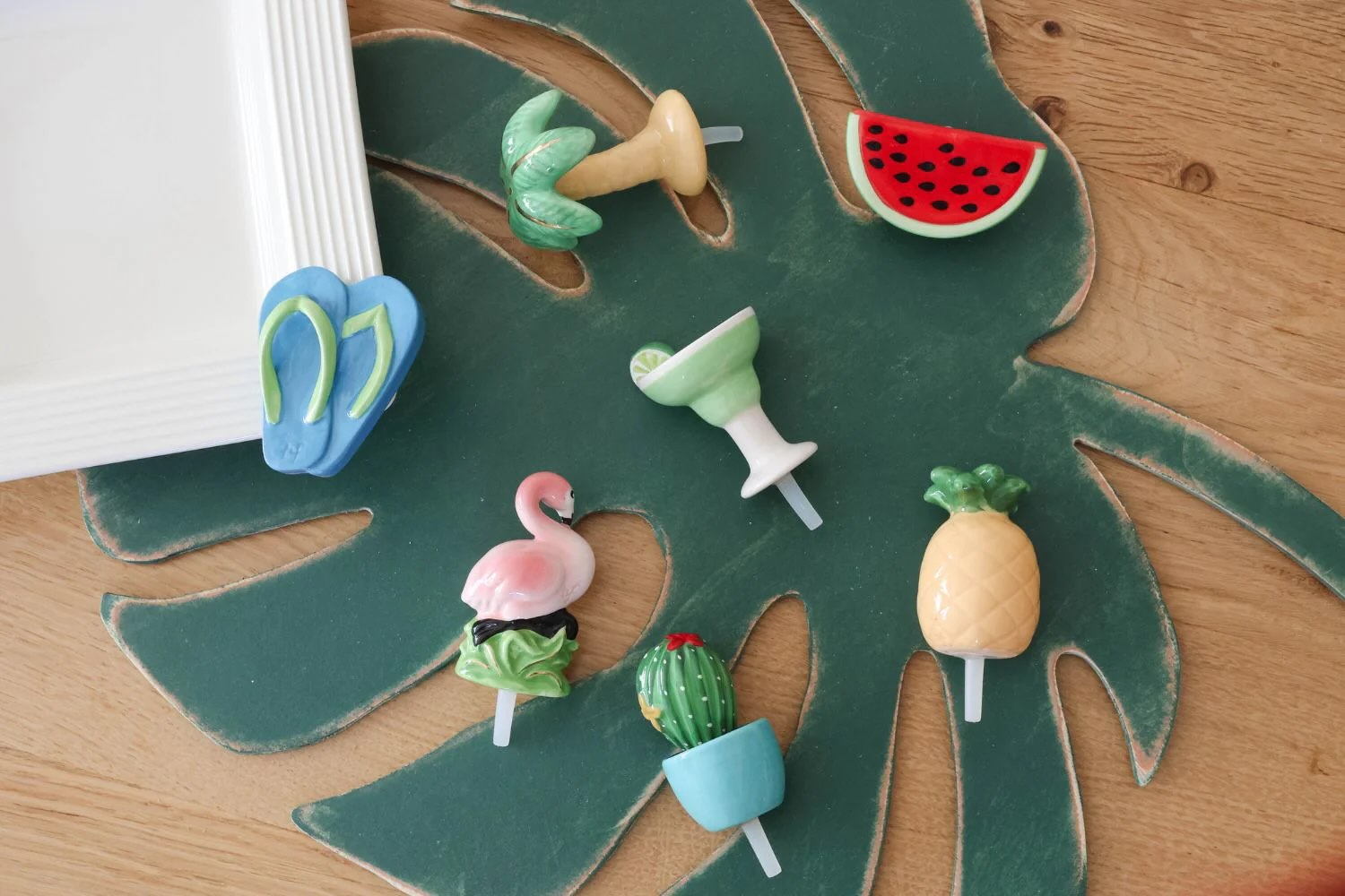 decorative wooden leaf with 7 Nora Fleming Minis laying on top of it